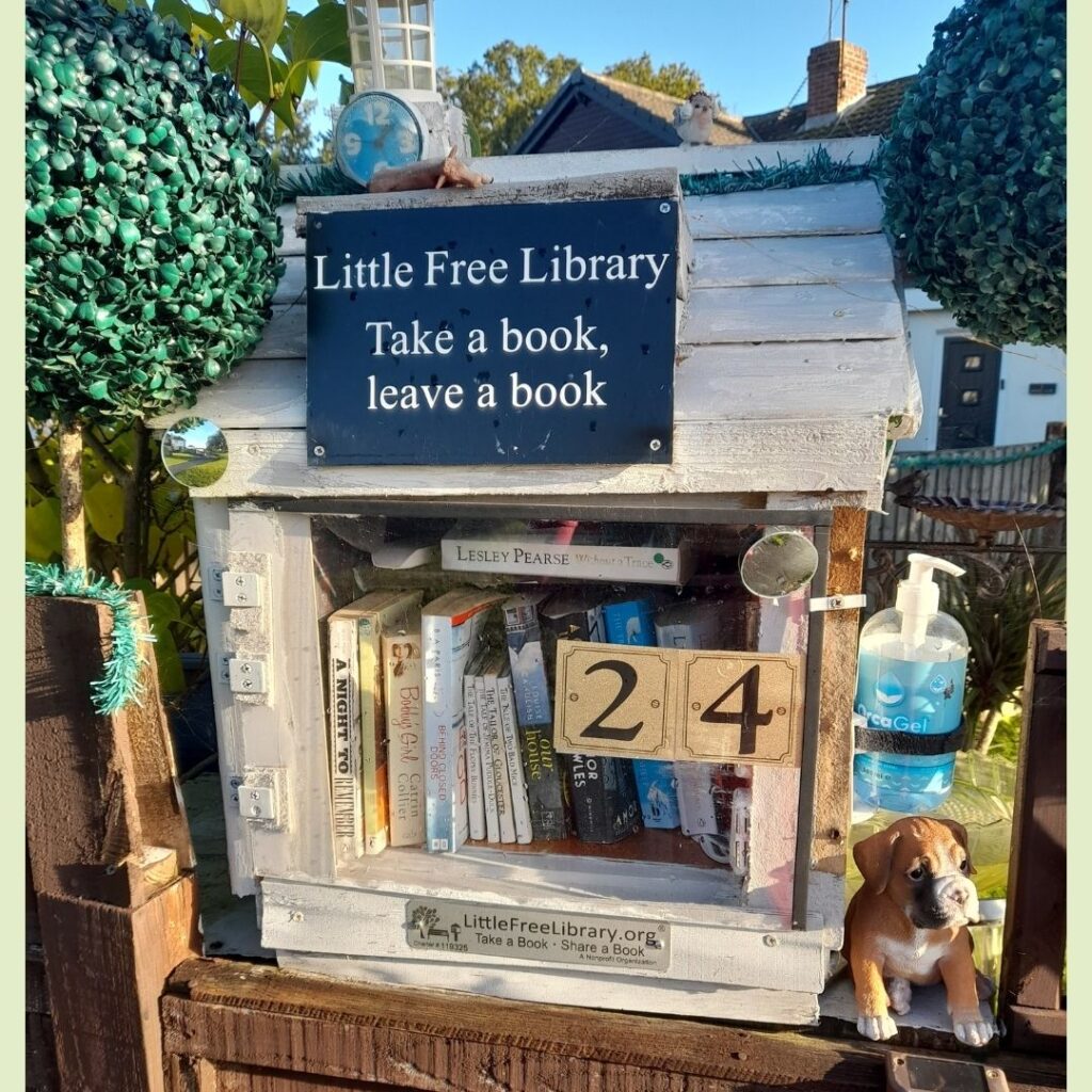 A photo of a little library cabinet with books inside it and a sign that reads take a book, leave a book
