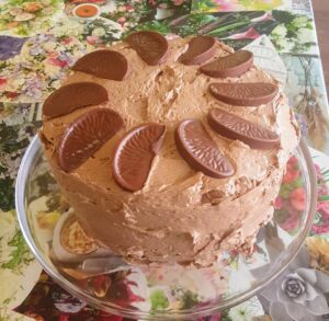 A delicious looking chocolate orange cake with Terry's chocolate orange slices around the top of it.