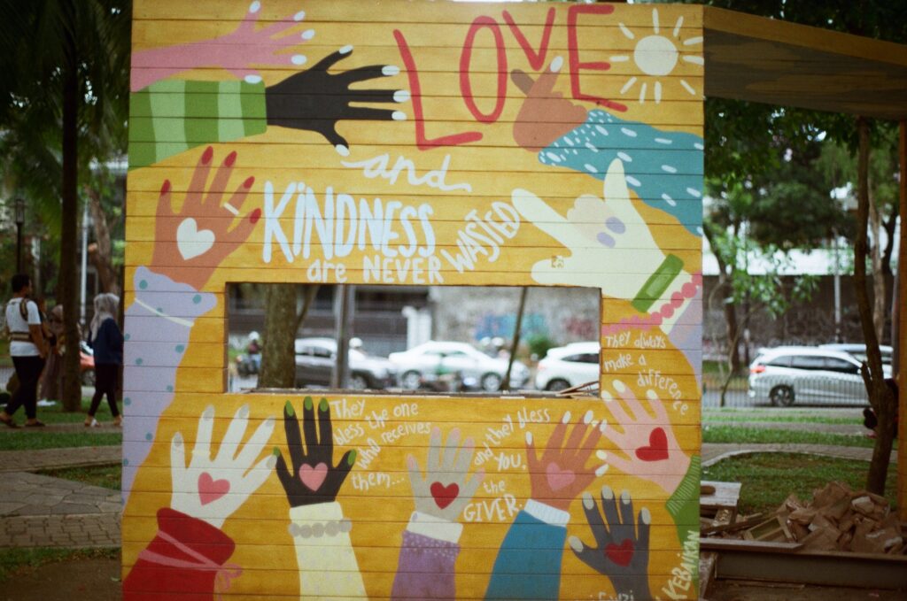 A wall with brightly coloured phrases related to the positivity of kindness painted all over it