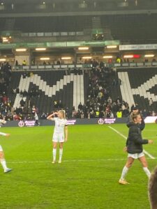 Leah Williamson on the football pitch at the Milton Keynes stadium after a match looking away towards the crowd