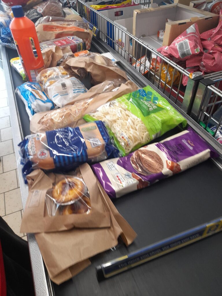 a conveyor belt at Lidl filled with food and cleaning items.