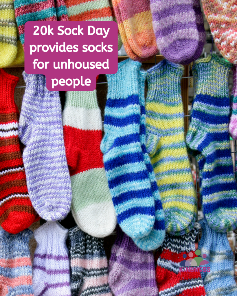 A variety of pairs of stripy socks in different colours. Text overlaid reads "20k sock day provides socks for unhoused people."