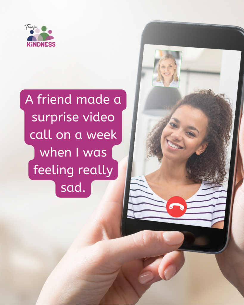 A hand holding a phone which shows a video call between two women. Text overlaid reads "A friend made a surprise video call on a week when I was feeling really sad."