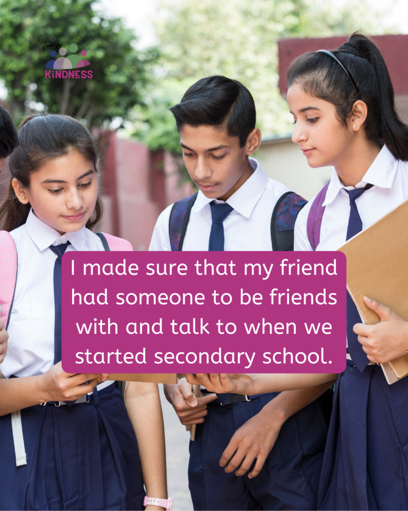 Three high school age children in school uniform, all with medium light skin tone gather around looking at a book one is holding open. Text overlaid reads “I made sure that my friend had someone to be friends with and talk to when we started secondary school.”