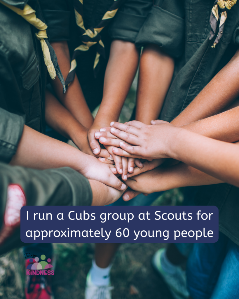 A small scout group put their hands one on top of the other in a circle. Text overlaid reads “I run a Cubs group at Scouts for approximately 60 young people.”