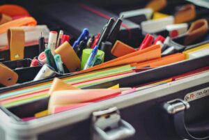 A selection of social science research materials such as coloured pens, post-it notes and folders