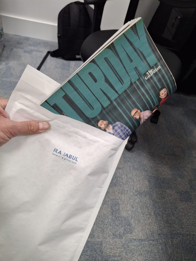 a folded over Guardian Saturday magazine sticking out of a white envelope.