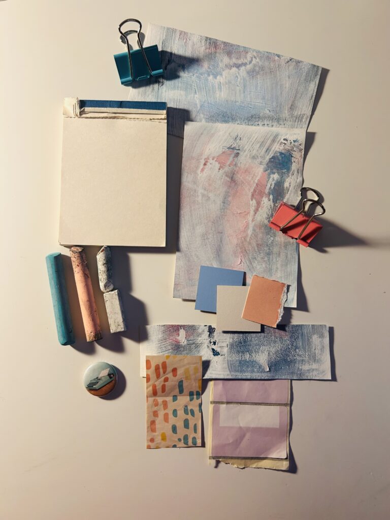A photo of assorted stationery items, including bull dog clips, different coloured papers, stickers etc