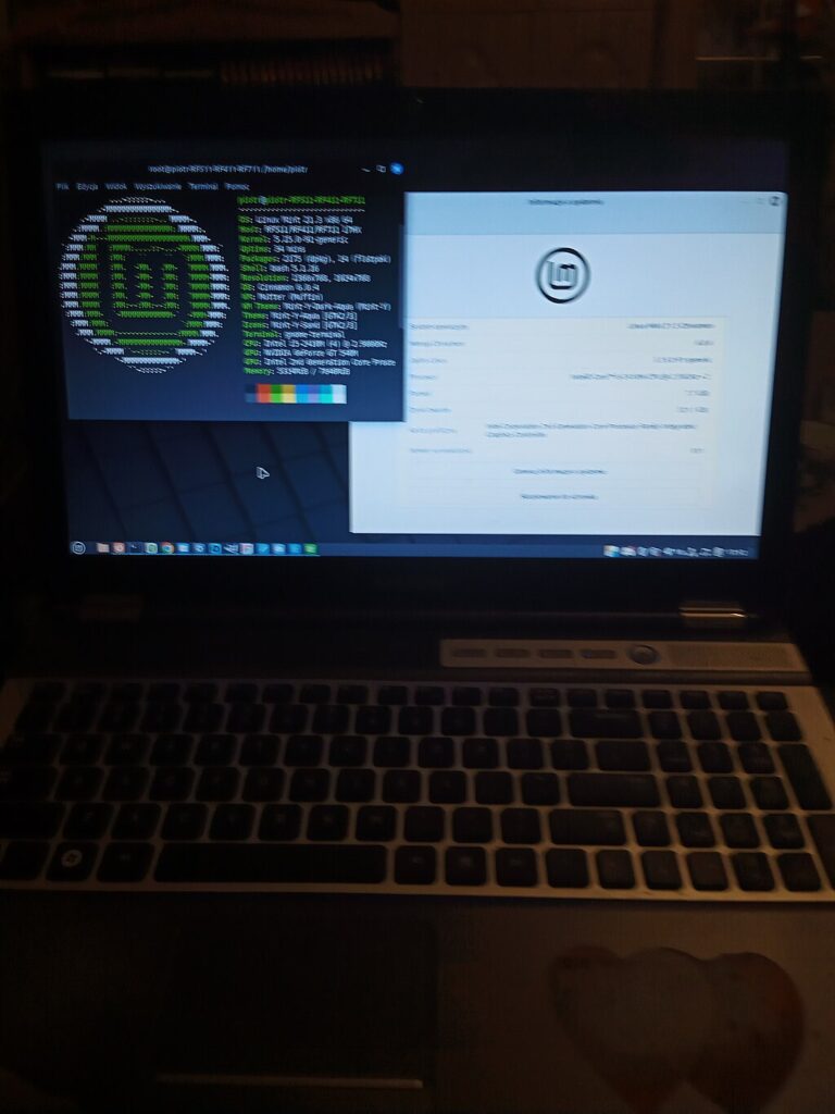 a laptop open to show the screen which has the Linux Mint info on it and the terminal open to show the Mint logo and information.