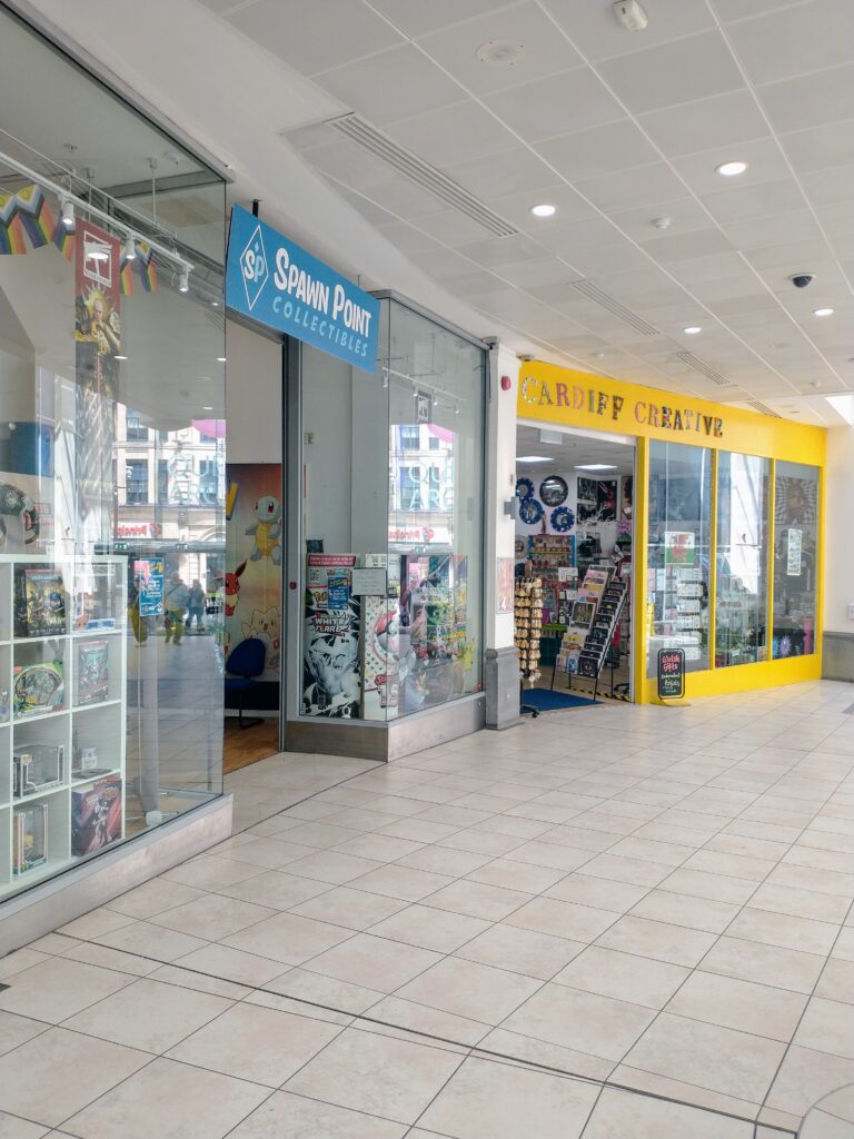 Part of a shopping centre with Spawn Point Collectibes in the foreground and Cardiff Creative next door.