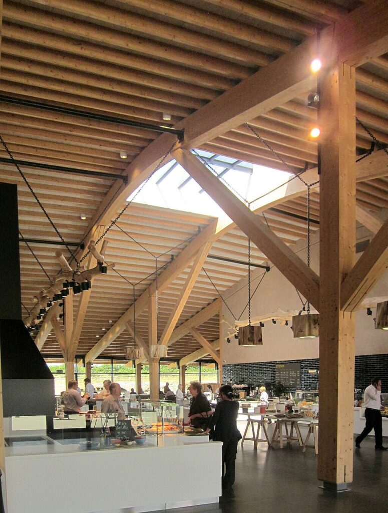 A food court area with people queuing and serving in Gloucester service station with high wooden ceilings.