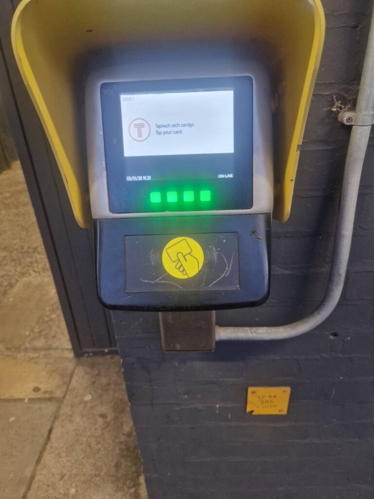 a tap on off machine outside a Transport for Wales train station.