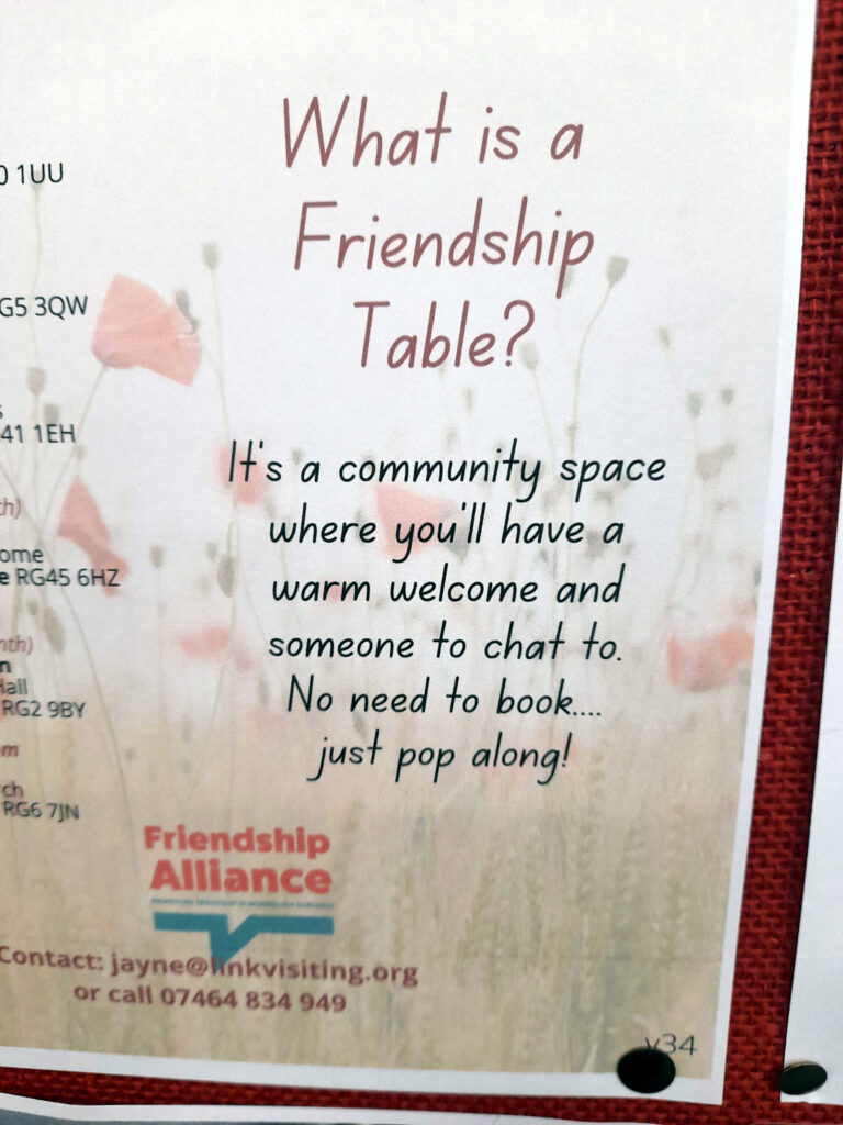 a poster which reads what is a friendship table? It’s a community space where you’ll have a warm welcome and someone to chat to. No need to book, just pop along!