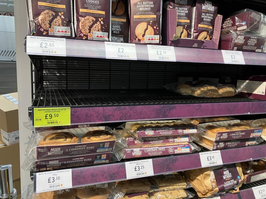 shelves at the M&S bakery, one shelf for Colin the Caterpillar cakes is entirely empty while the rest are full.