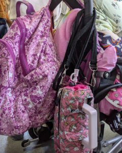 An array of pink bags on the back of a wheelchair